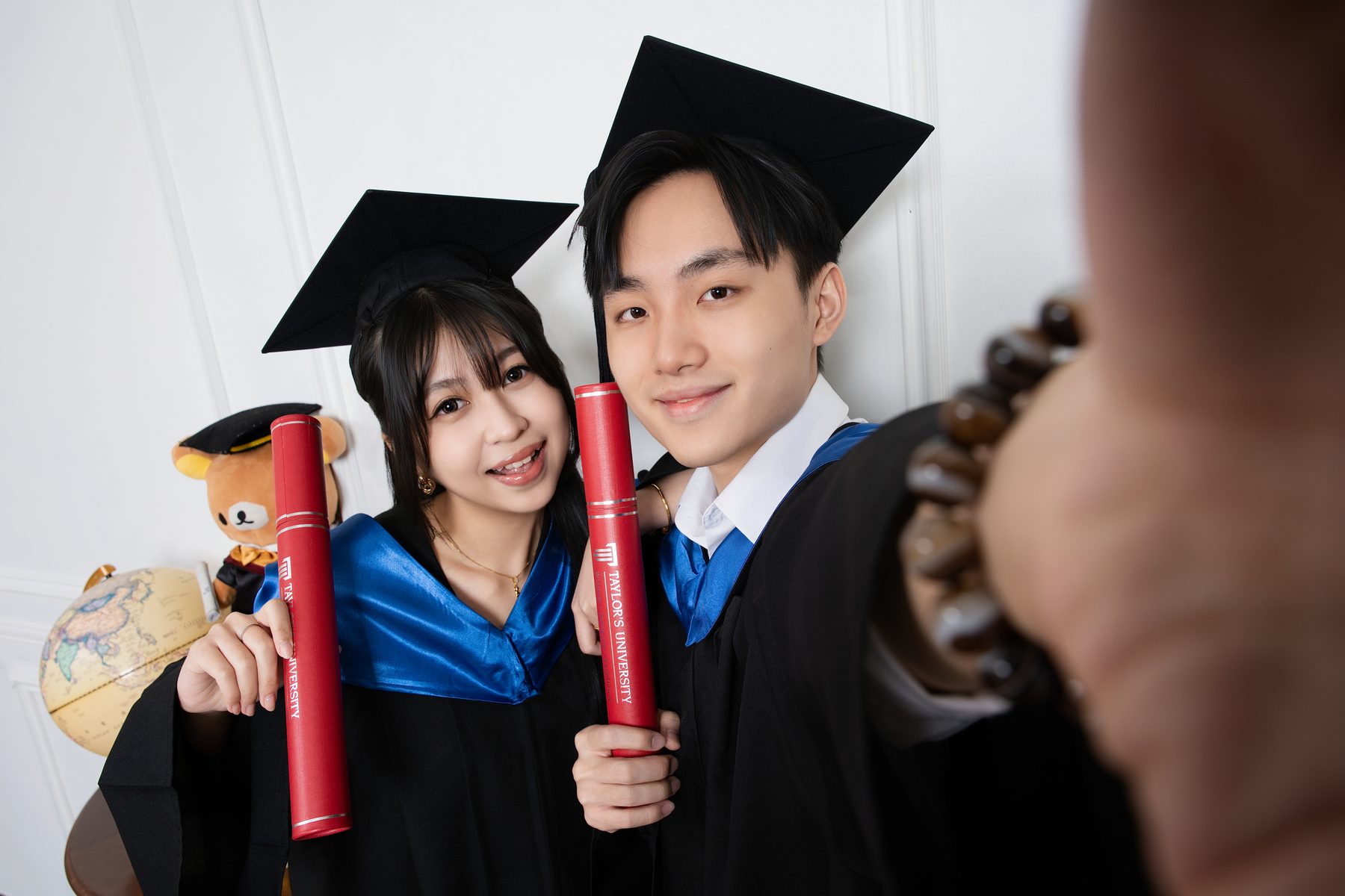 Real graduation photo at Premo Studio — solo graduate portrait with scroll