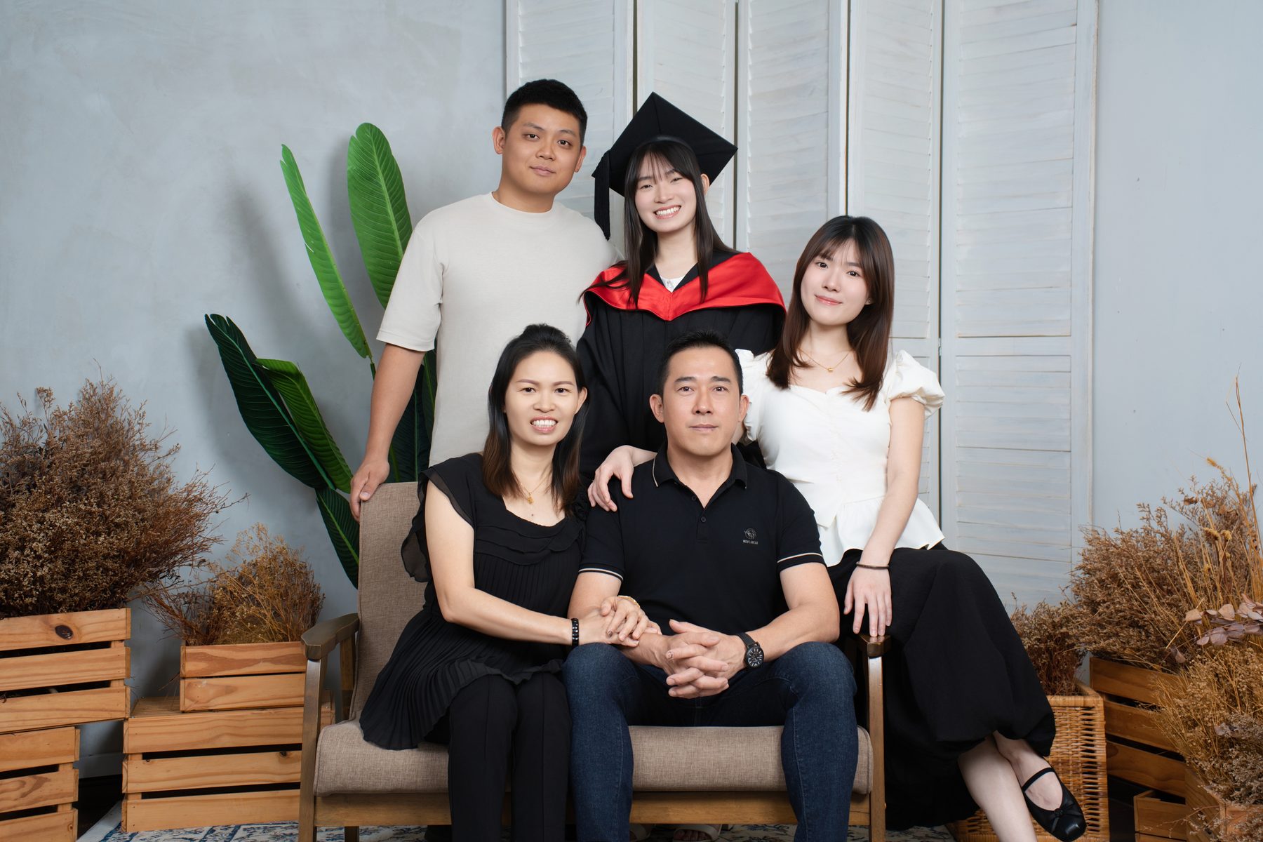 Premo Studio real client graduation photo — graduate seated with family