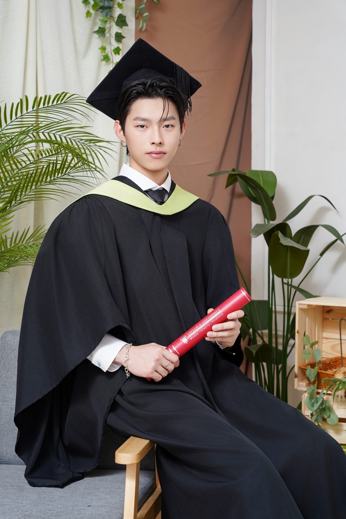 Premo Studio real client graduation photo — graduate portrait with greenery backdrop