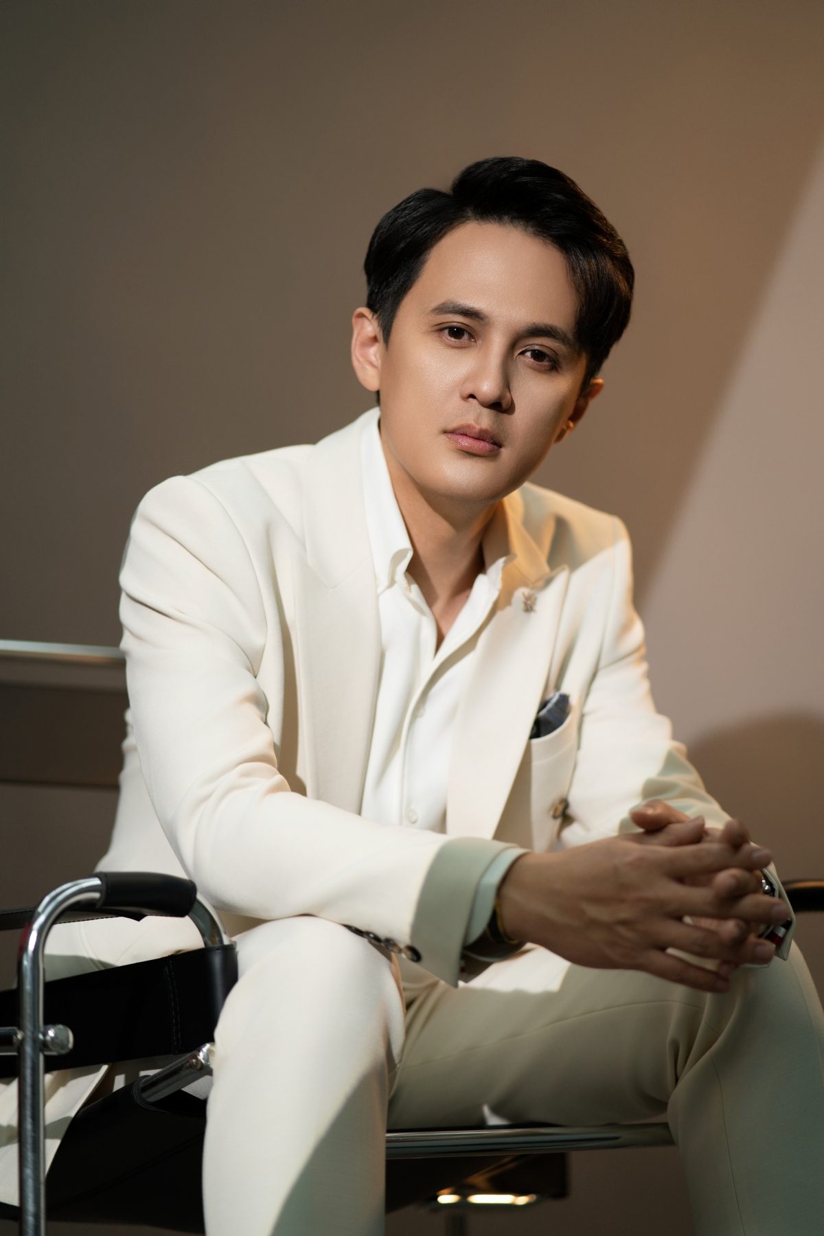 Premo Studio real client business portrait — man in white suit, seated pose
