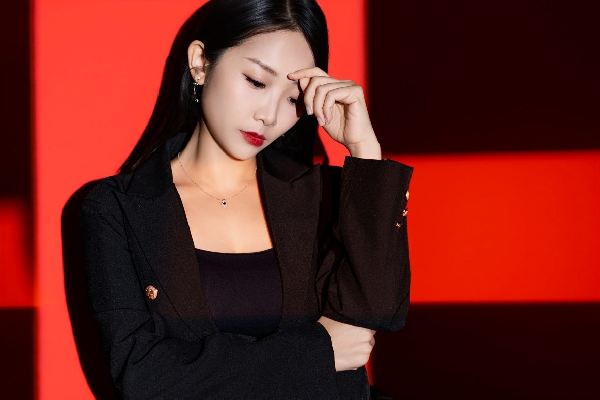 Premo Studio real client business portrait — woman, red backdrop, editorial style