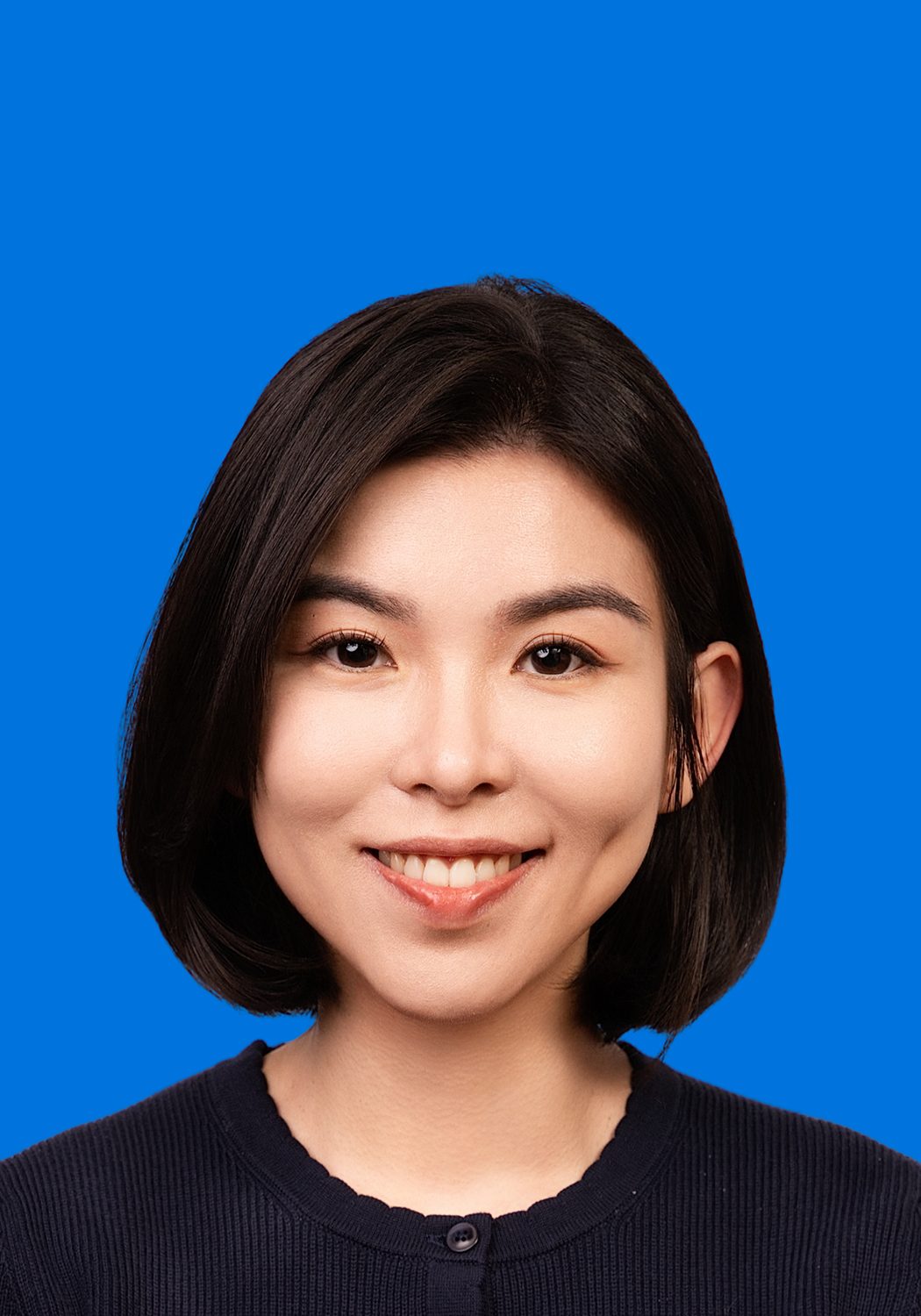 Premo Studio real client passport photo — woman, blue background